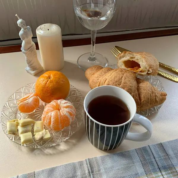 Aesthetic breakfast with hot tea, croissant and sweets