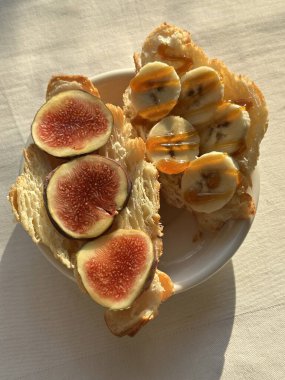 İncirli, muzlu ve ballı kruvasan. Masaya yakın plan.