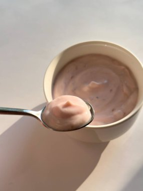 Beyaz arka planda bir kasede yoğurt.