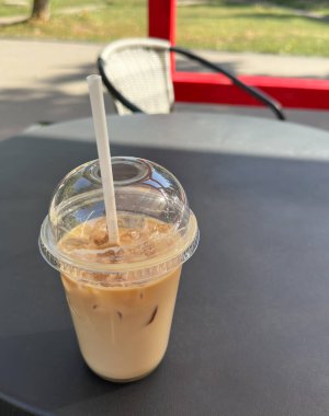 Bir kafe 'nin yaz terasında masada buzlu latte.