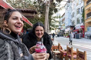 Anne ve kızı kışın birlikte vakit geçirip serinlemek için nar suyu içiyorlar. Açık havada gezmek ve şehirde meyve suyu içmek eğlenceli..