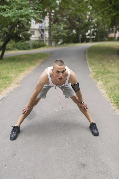 Close up image of a male body stretching a leg before workout