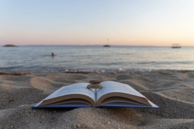Gün batımında deniz kenarında kitaplar. Okul kavramı