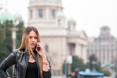 Uzak uygulama üzerinden cep telefonuna ulaşın ve Sokağı'nda gezinme sırasında arayan muhteşem dalgın kadın. Becerikli alet ile bahar kentsel ayarda yürürken boş vaktinizi rüya gibi hippi kız