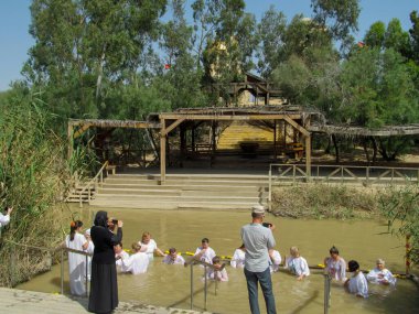 Yericho, İsrail - 18 Ağustos. 2012: Ürdün nehrinin sularında beyaz elbiseli dindar Hıristiyanlar vaftiz bölgesi Qasr el Yahud, Yericho yakınlarında.