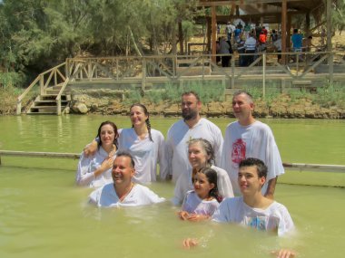 Yericho, İsrail - 18 Ağustos. 2012: Ürdün nehrinin sularında beyaz elbiseli dindar Hıristiyanlar vaftiz bölgesi Qasr el Yahud, Yericho yakınlarında.