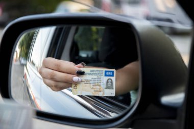 Sınavı geçtikten sonra ehliyetini vitrinde gösteren genç kız ya da trafik polisinin isteği üzerine