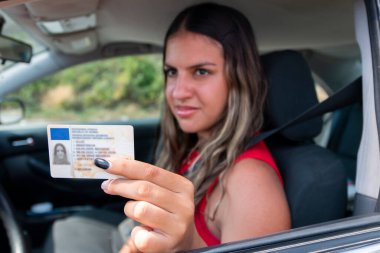 Sınavı geçtikten sonra ehliyetini vitrinde gösteren genç kız ya da trafik polisinin isteği üzerine