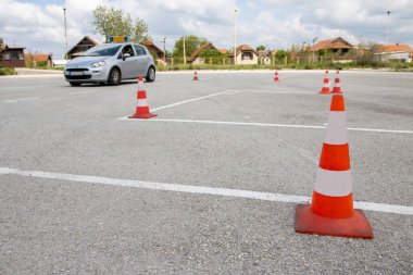 Ehliyet kursu ya da sınav. Eğitim parkı. Koniler arasında araba sürmeyi ve park etmeyi..