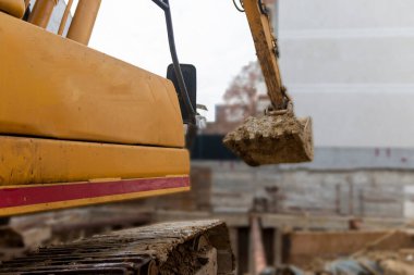 İnşaat kazıcısı inşaat alanında çalışıyor. Proje devam ediyor.