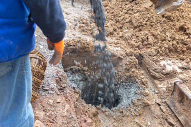 Yeni inşaat alanı için temel yığınlarının somutlaştırılması. Yeni binanın güçlendirilmiş beton yığınları..