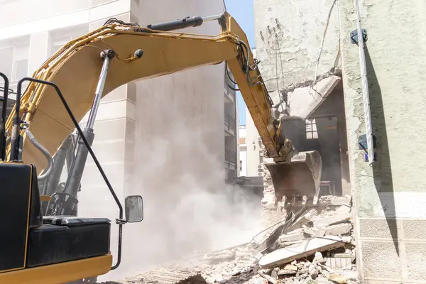 Eski binanın sökülme işlemleri devam ediyor. Kazıcı evi yıkıyor. Yeni gelişmeler için harap olmuş konutların tahrip edilmesi