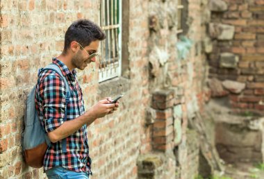 Yakışıklı adam mesaj yolluyor. Genç adam dışarıda duruyor ve mesajlaşıyor. .