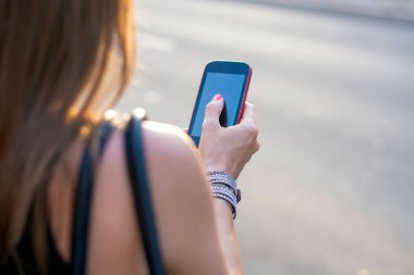 Sokakta bir akıllı telefon kullanan kadın