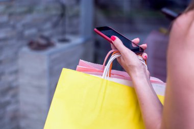 smartphone ve alışveriş torbaları kadın ile