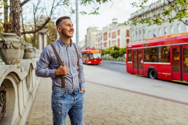 Ekose gömlekli şehrin yürüme ve duygu neşeli ve kendine güvenen genç turizm