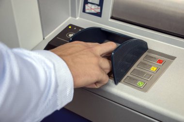 ATM makinesi ve yakın plan adam pin tuşuna basıyor. ATM arama paneline kişisel kimlik numarası girildi 