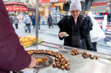 Sokaktan mısır alan şapkalı bir kadın. Sokak yemeği..