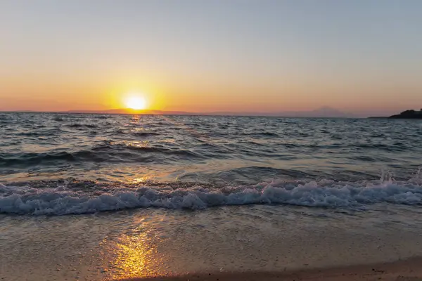 Sahildeki altın kumda deniz dalgaları. Günbatımlı ya da gün doğumlu güzel tropikal doğa deniz okyanusu