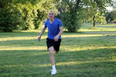 Yakışıklı genç sporcu çalıştıran ve genel parkta koşu