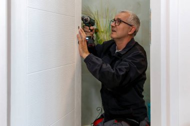 Ahşap kapıya bir kilit takıldı. Tornavida, marangoz tarafından kapı kollarına kilit takmak için kullanılır.