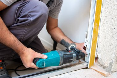 Profesyonel marangozlar yeni bir daireye giriş kapısı kuruyor. Kapı tamircisi eskisini yenisiyle değiştirdi.