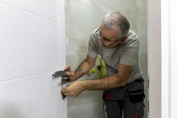 Ahşap kapıya bir kilit takıldı. İnsan evdeki işlemleri kontrol etmek için ruh seviyesine ulaşır.