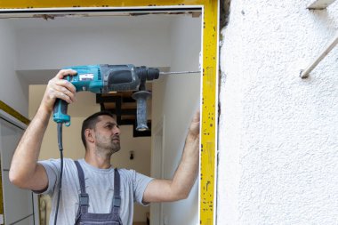 Profesyonel marangozlar yeni bir daireye giriş kapısı kuruyor. Kapı tamircisi eskisini yenisiyle değiştirdi.