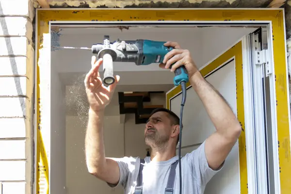 Profesyonel marangozlar yeni bir daireye giriş kapısı kuruyor. Kapı tamircisi eskisini yenisiyle değiştirdi.