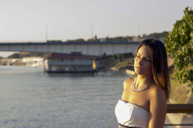 Nehrin kenarında uzun saçlı çekici bir kadının portresi.