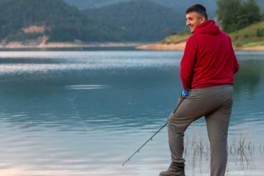 Sırt çantalı genç adam gölde