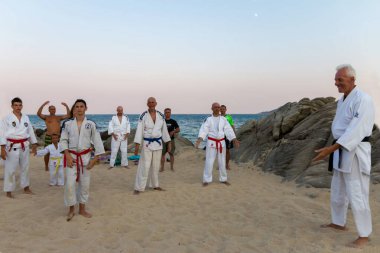  Sahilde aikido öğreten bir grup insan.