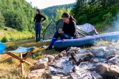 Bir anne ve kızı kamp yaparken birlikte vakit geçirir. Bir anne şenlik ateşinin yanındaki şişme yatakta oturuyor ve kızı yanında duruyor..