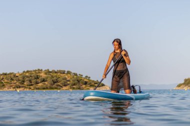 Genç bir kadın Denizde bir pano ile