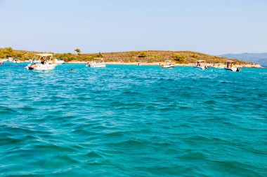 Mavi deniz ve orada bir sürü tekne var.