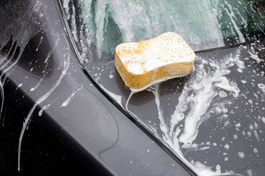 Araba yıkama. Otomobili köpükle temizlemek. Araba oto yıkama servisi sırasında köpük şampuanla kaplanmış kimyasal deterjanlar.