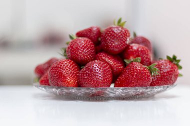 Bir tabakta taze kırmızı çilek. Yaklaş.