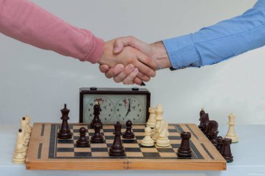 Baba ve kızı, satranç figürünün hareketine yönelik düşünme stratejisinden sonra el sıkışıyorlar.