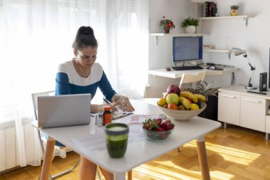 Beslenme uzmanı, diyetisyen kadın bir diyet planı yazıyor, masada sağlıklı meyveler var. Haftalık yemek organizatörü. Sağlık ve diyet konsepti. 