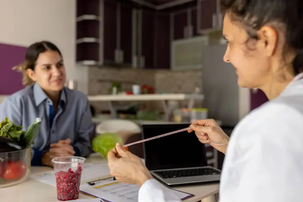Doktor, diyetisyen müşteriyle sağlık sorunları ve sağlıklı yemek yemenin önemi hakkında konuşuyor. Genç kız için bireysel diyet planı yapıyorum. Diyet, sağlıklı beslenme, zayıflama ve kilo verme konsepti