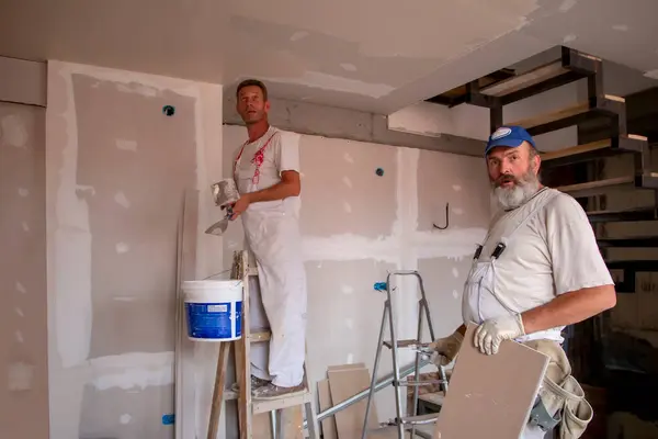 Apartman tamiri kavramı. Ev yenileme işçileri. Yenileme, yenileme, uzatma, restorasyon, yeniden yapılanma ve inşaat (modernizasyon) altında bulunan evde (bina) yeniden yapılanma ().