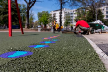 Yeni çocuk parkı yapım aşamasında. Bir mason el ile mala yayılan ve düzleştiren yumuşak lastik kırıntılar lastik malç