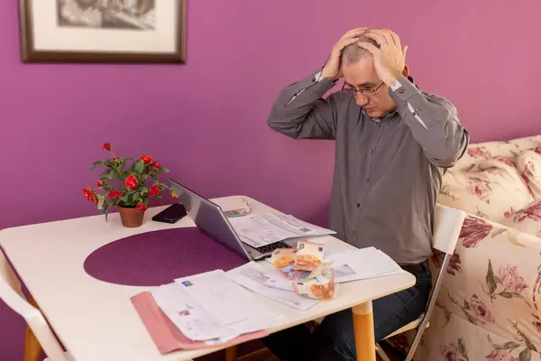 stock image Worried mature man is confused and astonished by unbelievable news: debt notification, bad financial report, high bill tax invoice, money problem