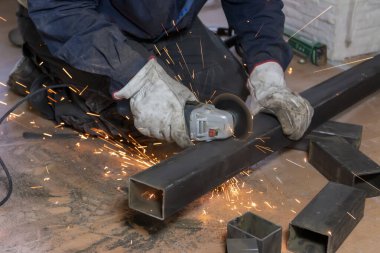 Ustanın elleri metal parmaklıkları öğütücüyle gördü. Metal işe yarıyor. Kapat.