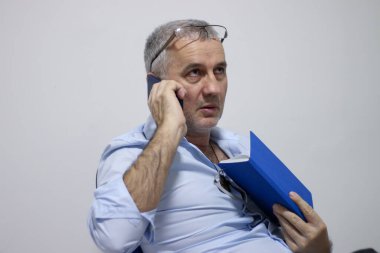 Endişeli orta yaşlı işadamı iş yerinde sorun yaşıyor, iş meselelerini çözüyor, evrak işleriyle uğraşıyor. Bitiş tarihi, faturalar, borç ve kredi kavramı.