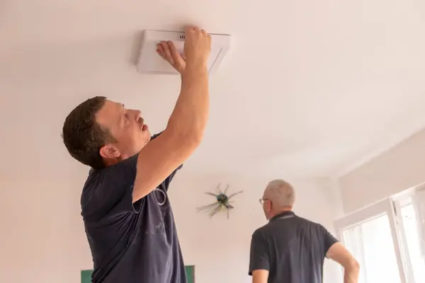 stock image Concept installation of a ceiling led light. Hands of an electrician are installing and connecting a lamp to a ceiling. . Restoration in closed space.