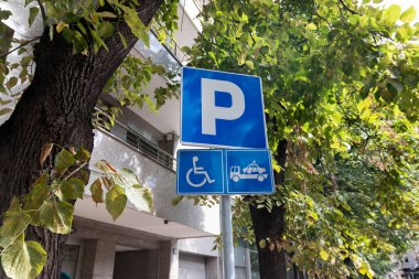 Sadece engelli sürücüler için park yeri. PWD için boş park alanı; yol işaretleri ve bilgi işareti ile gösterilir. Engelli kişi için uyarlanmış alanlar. İçerme.