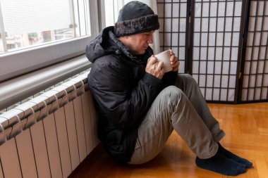 Çay içen ve ısıtma faturasıyla sorunu olan olgun bir adam. Gaz faturasının maliyetini arttır. Artan enerji fiyatları. Doğal gaz fiyatlarında artış var. Avrupa 'da enerji krizi.
