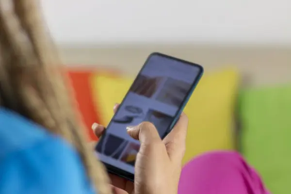 Kadın el ele tutuşan telefon. İnternet üzerinden mobil alışveriş uygulaması kullanan genç kız müşteri alışverişi cep telefonu ödemeleri ile satın almayı seçiyor.