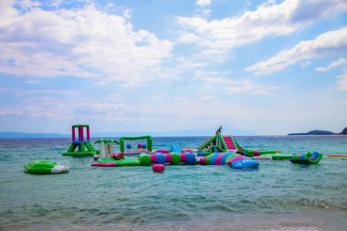 Şişme şişme şato su üzerinde yüzüyor. Su parkında eğlenen çocuklar için bir park. quapark deniz eğlenceleriyle dolu. Popüler turist aktiviteleri, su sporları.